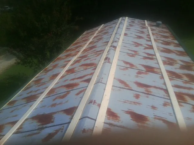 Rusted metal roof panels with new wood purlins before replacement — Storm Damage Roof Repair in West Baldwin by Roofing Brothers