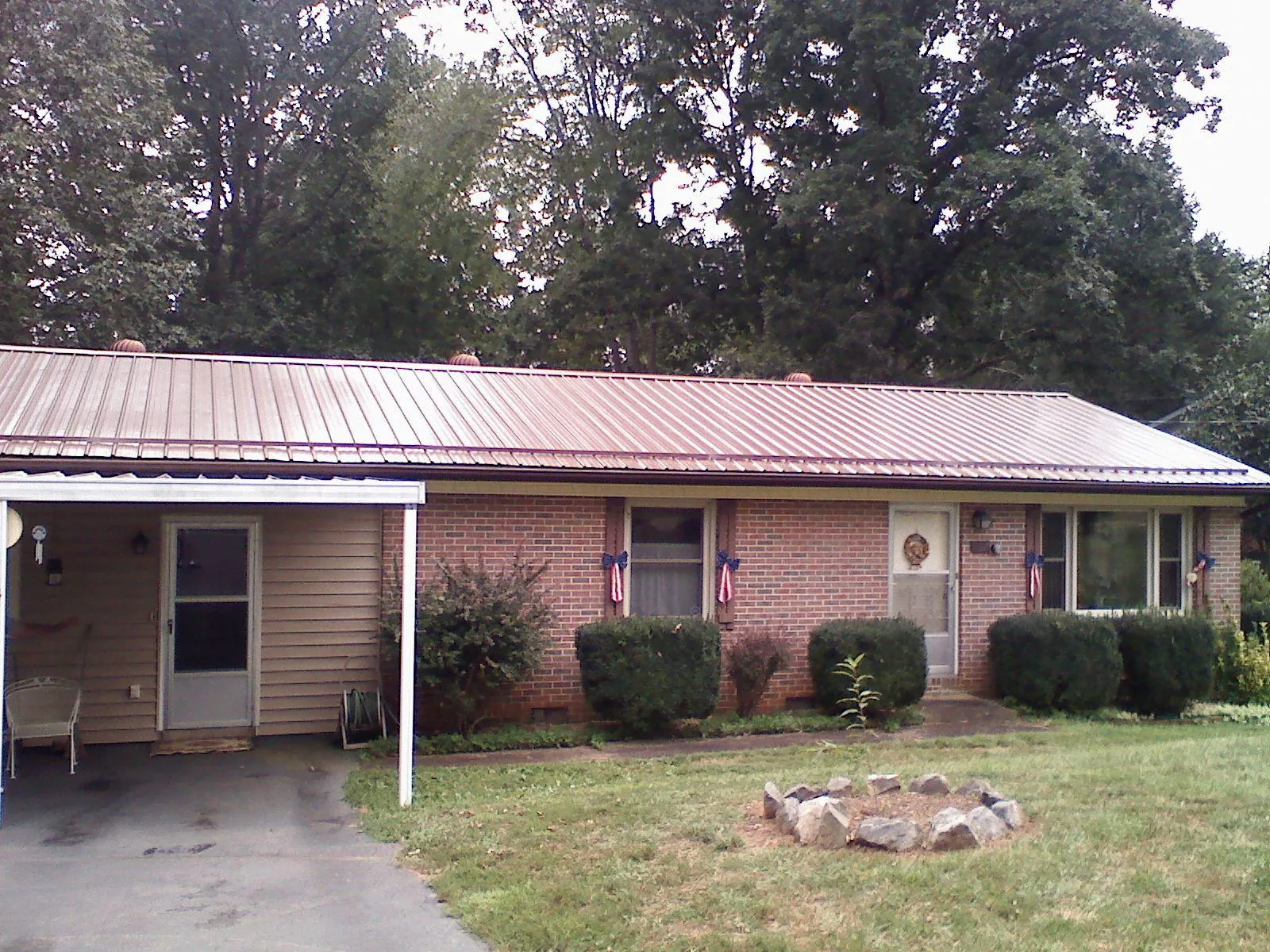 Bronze metal roof and carport on a brick ranch home — Roof Repair work by our crew in West Baldwin